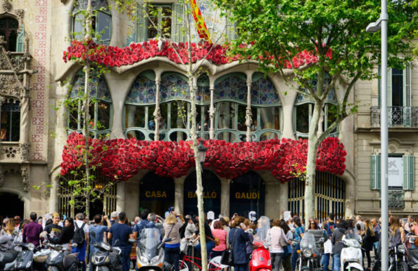 Fachada de la Casa Batlló de Antoni Gaudí decorada con rosas rojas en los balcones durante la festividad de Sant Jordi en Barcelona con referencia a la leyenda del dragón